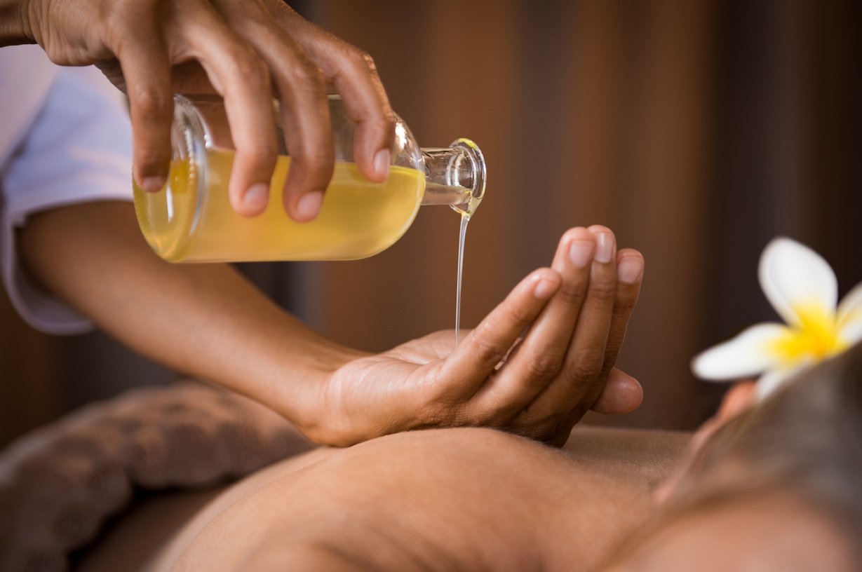 Therapist pouring massage oil at spa