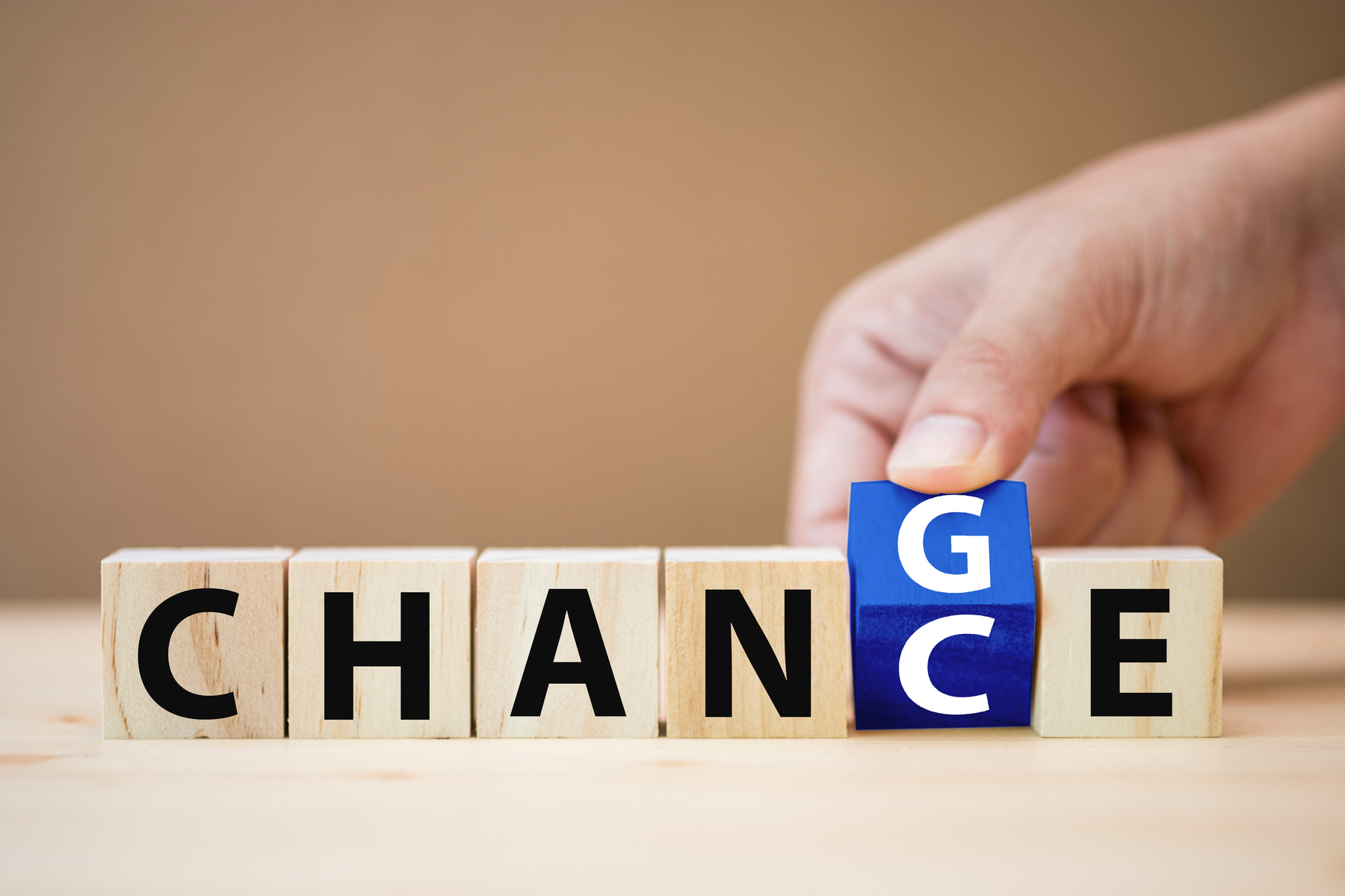 Hand flipping wooden cubes for change wording between "change" to "chance". Mindset for career growth business.