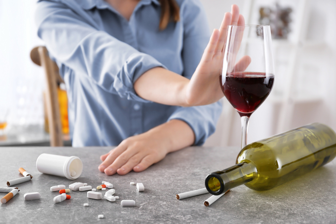 Young Woman Refusing Glass of Wine While Sitting at Table