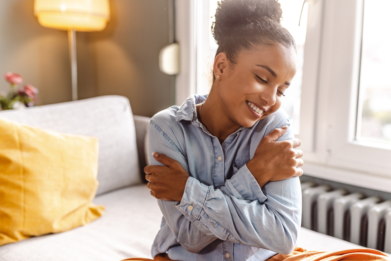 Smiling beautiful woman hugging self