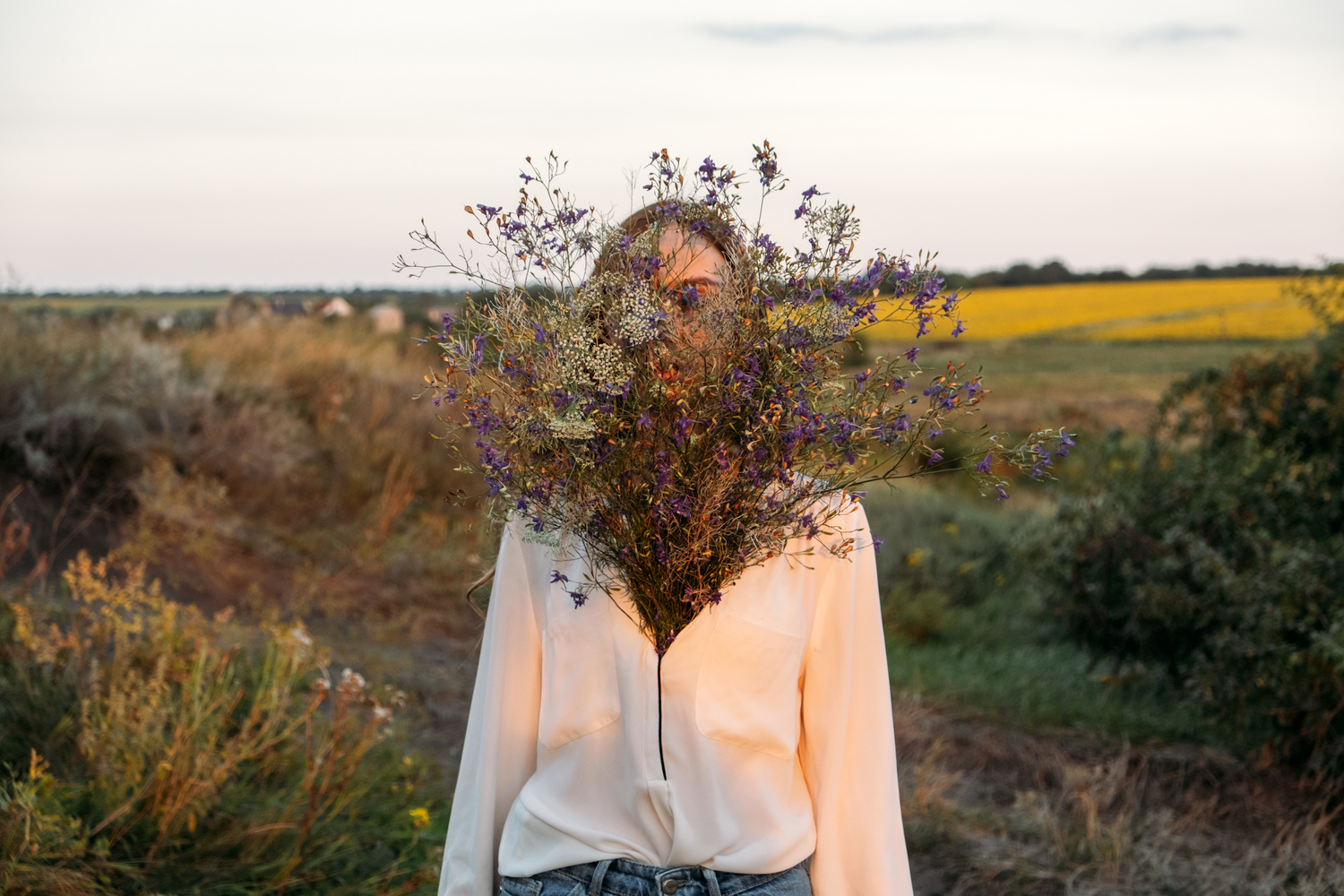 Celebration of Self, inner beauty, self-love, self-soothing, self-celebration. Happy young girl holding wildflowers bouquet, relaxing and enjoying life